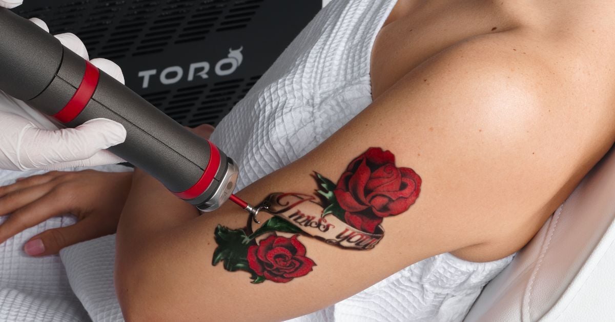 A closeup of a human arm with two red roses tattoos